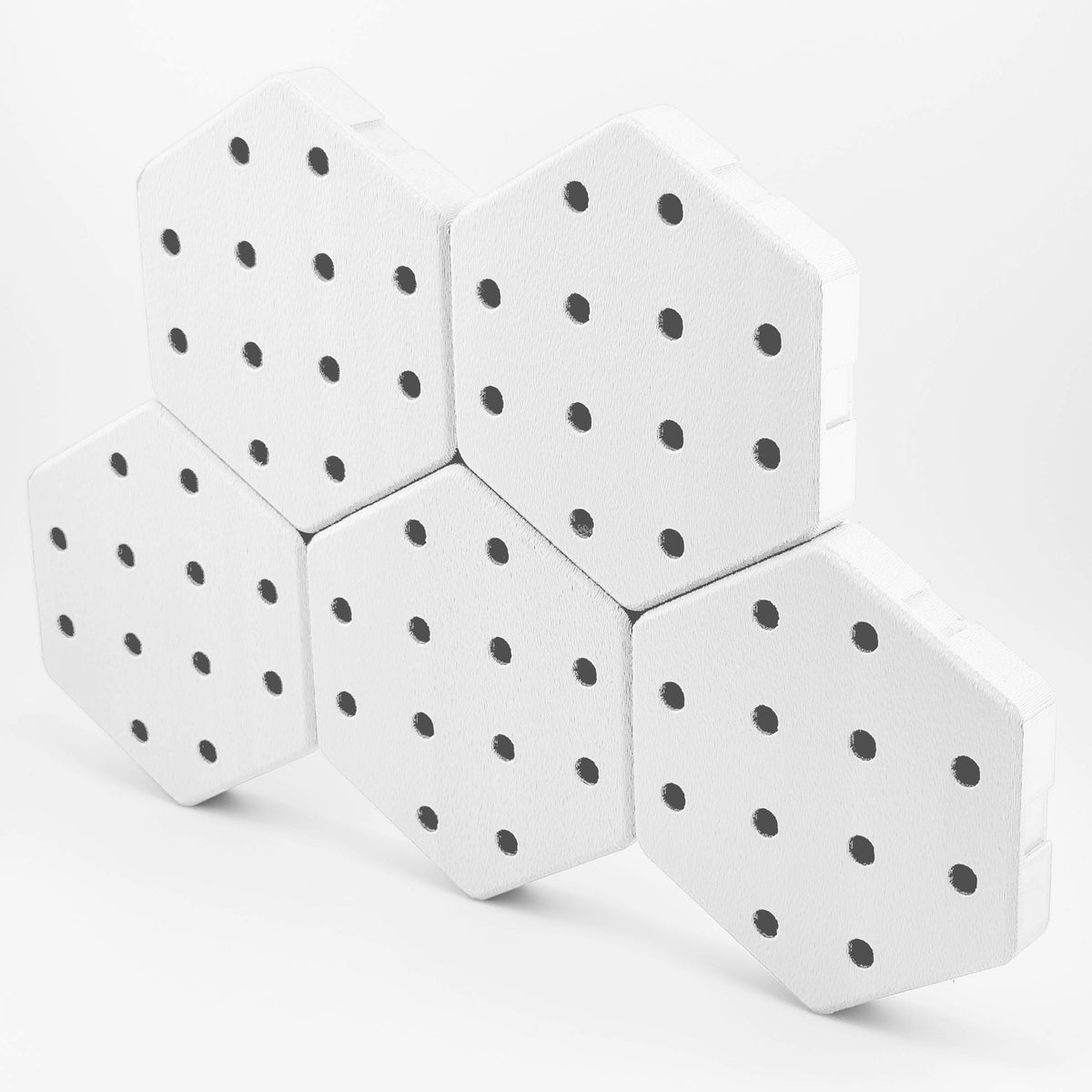 Five connected Hexboard hexagon pegboard tiles in Snow White.