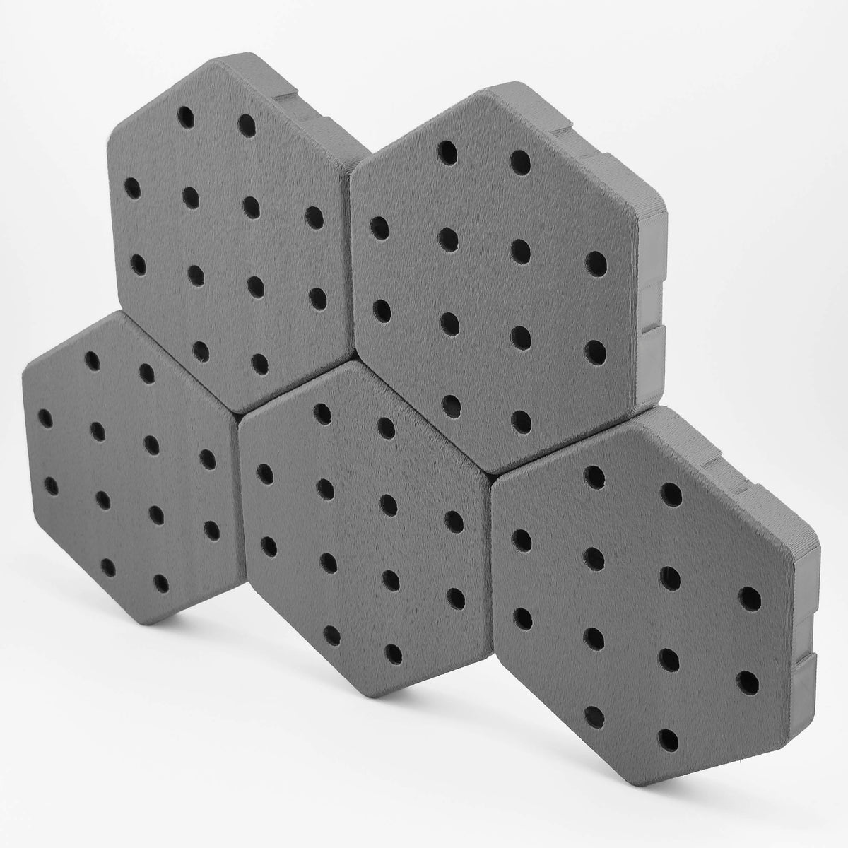 Five connected Hexboard hexagon pegboard tiles in Space Gray.