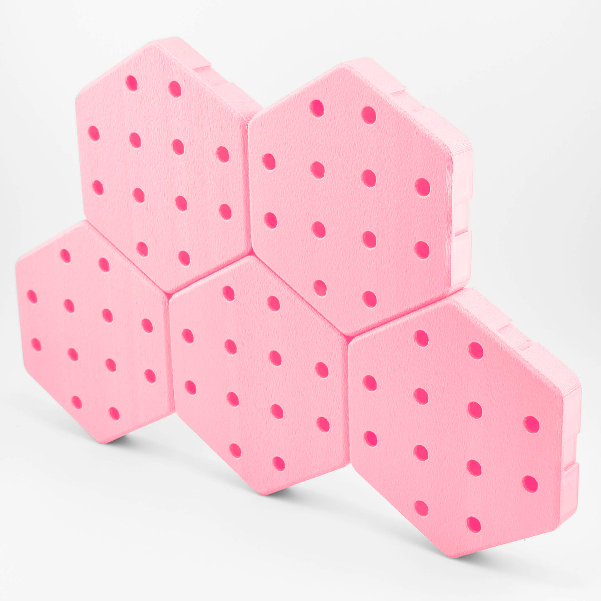 Five connected Hexboard hexagon pegboard tiles in Peony Pink.
