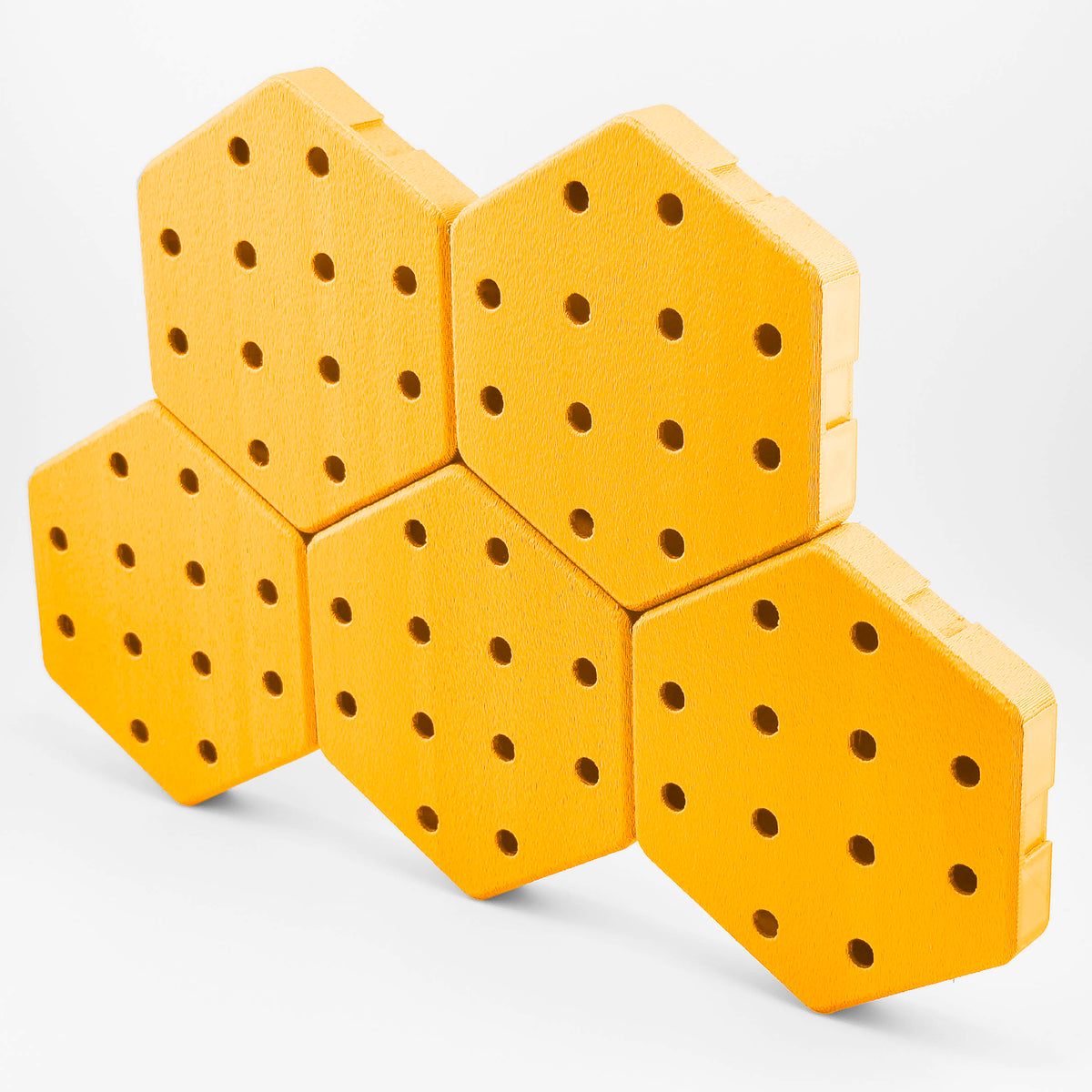 Five connected Hexboard hexagon pegboard tiles in Sunshine Yellow.