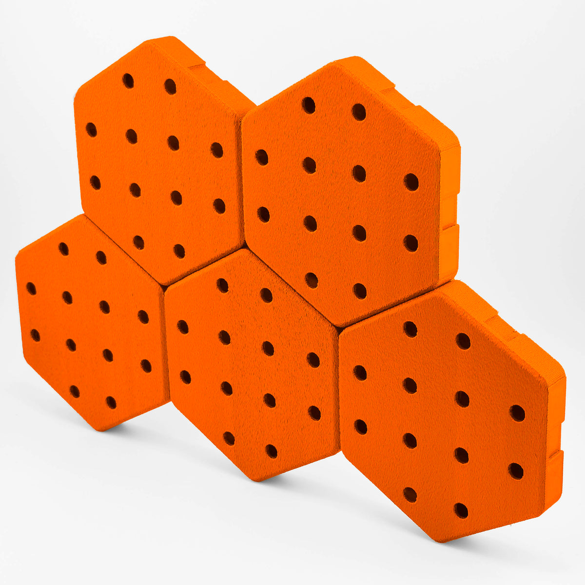 Five connected Hexboard hexagon pegboard tiles in Tango Orange.